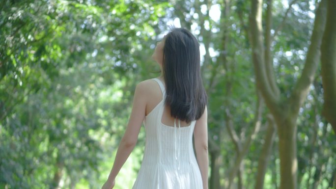 女孩在树林行走的背影，惬意舒适