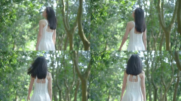 女孩在树林行走的背影，惬意舒适