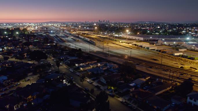无人机飞越商业和货运场的房屋，前往洛杉矶市中心