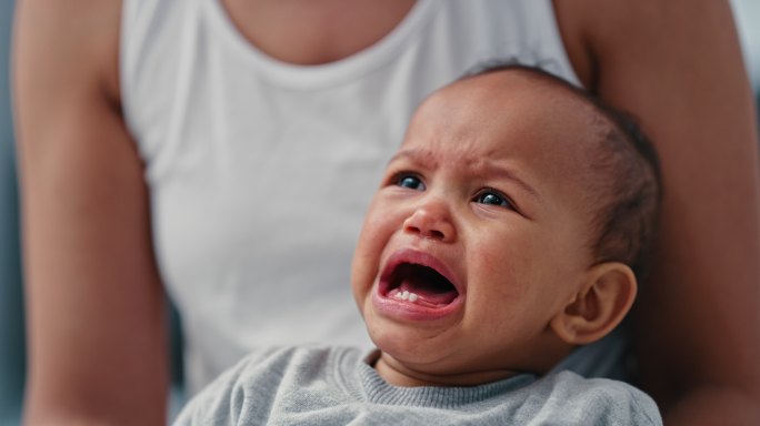 一个小男婴被母亲抱着哭泣的4k视频片段