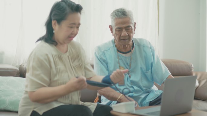 亚洲老年夫妇在家检查血压。