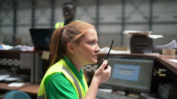 一名中年女性在工厂/行业使用无线电通信的肖像