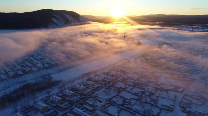 航拍冷空气笼罩森林小镇雪景