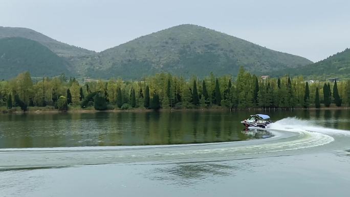 山水画卷柳树倒影摩托艇划过湖面
