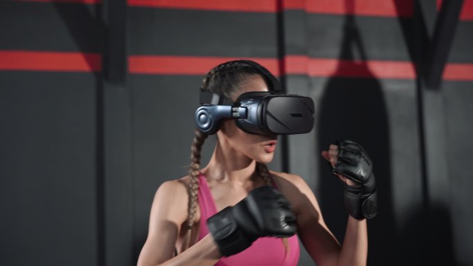亚洲女性戴着VR耳机和拳击