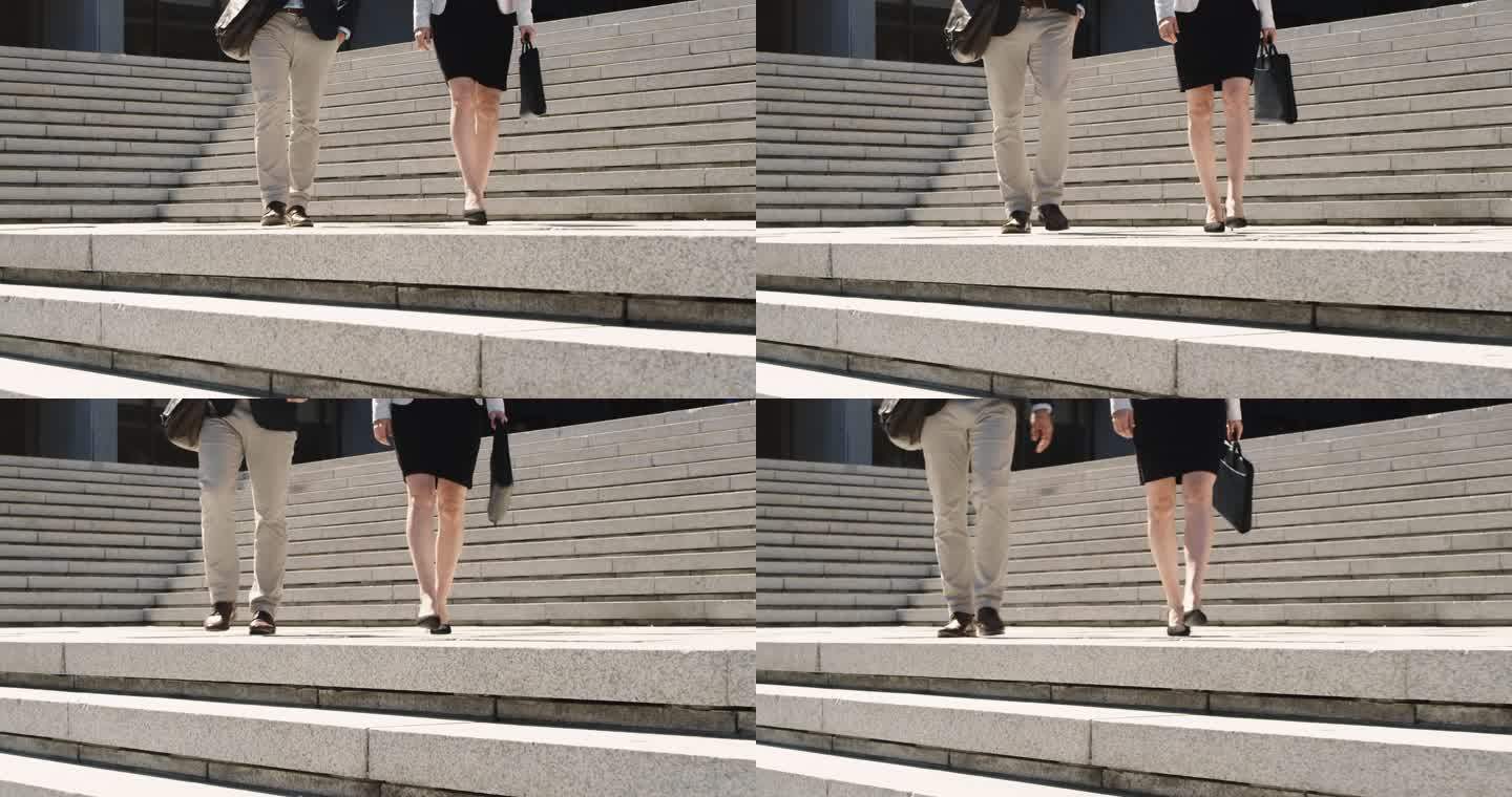 一名商人和女商人在城市背景下走下楼梯的4k视频片段