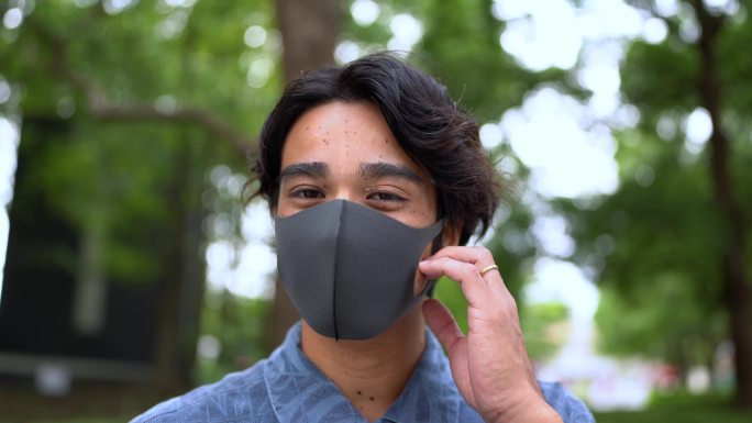 亚洲男子从脸上摘下面具的肖像。冠状病毒概念结束视频。