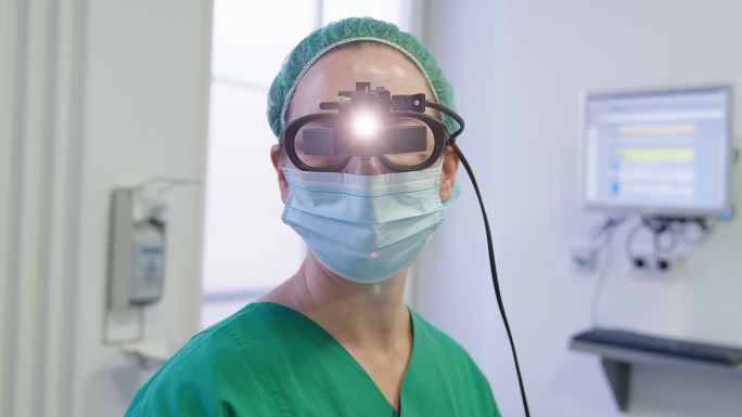 眼科医生戴眼镜手术用医用前照灯的肖像