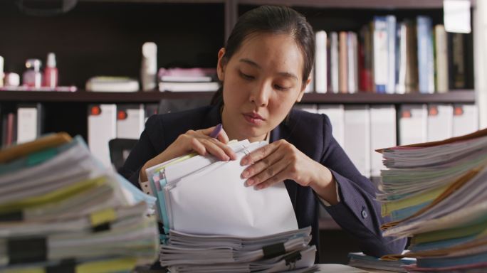 女商人在办公室里处理财务文件堆