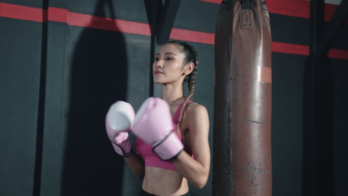 年轻的亚洲女性在拳击课前热身。