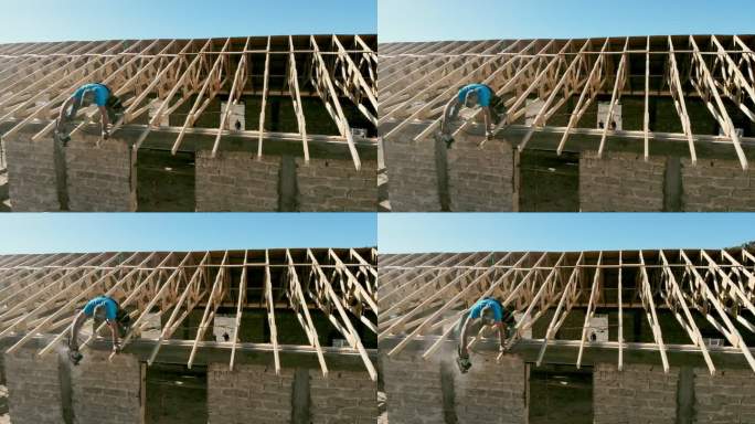 一位在新建筑屋顶上工作的木匠