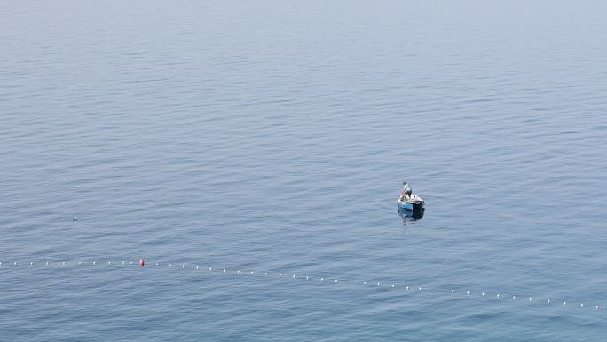 海景，一个渔夫在公海中的一艘小船上。