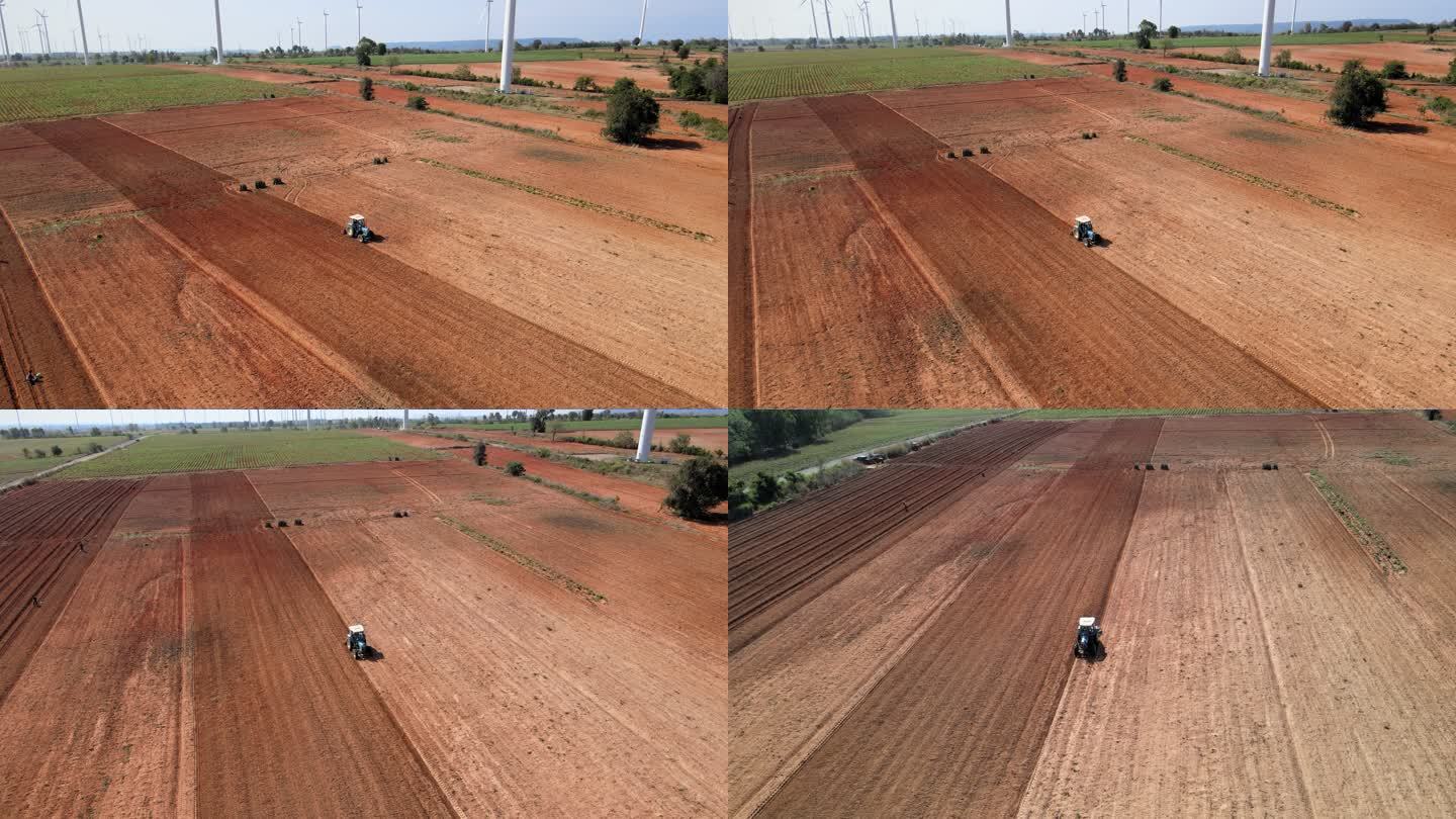 无人机视图，鸟瞰拖拉机在农田中开沟播种农用拖拉机。