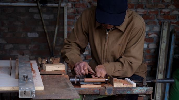 这位老木匠用车床加工木材部件。