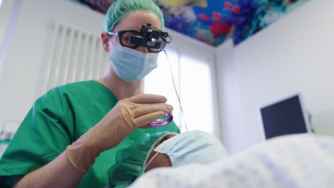 眼科医生用放大镜检查病人的眼睛