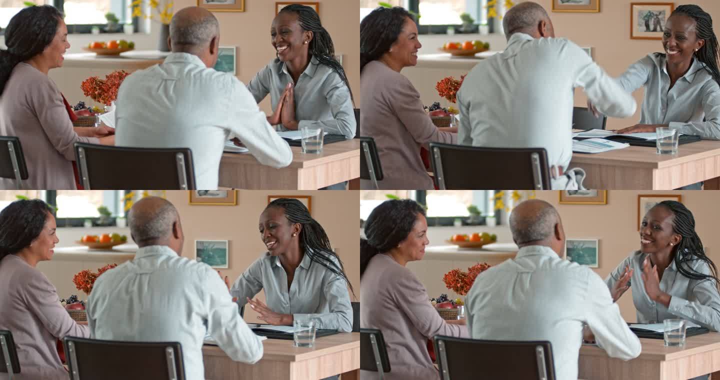 非裔美国私人银行家在家与一对老年夫妇握手