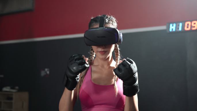 亚洲女性戴着VR耳机和拳击