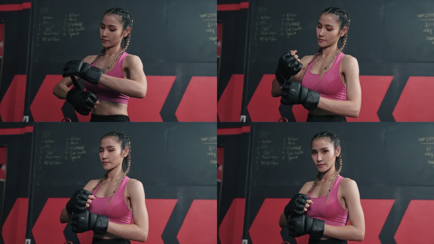 亚洲年轻女子在日常训练前戴上拳击手套。