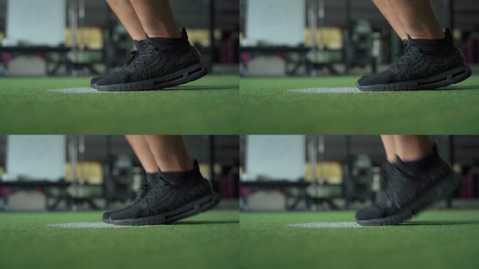 在室内健身房，穿着运动鞋的男子双脚跳绳的慢动作镜头。