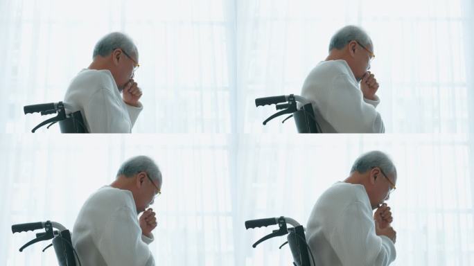 亚洲老年男性独自坐在轮椅上，退休后留在家里。不开心的老年残疾人咳嗽，担心医疗问题。医院医疗保健和医疗