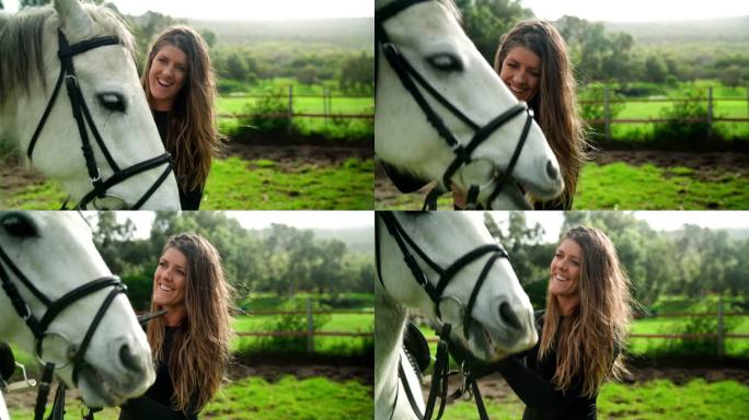阳光明媚的农村围场上骑着白马的快乐女人