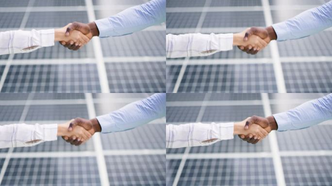一位无法辨认的非洲裔美国男子和白人女子在安装太阳能电池板时握手致意的特写镜头。两位不同的同事为建筑交