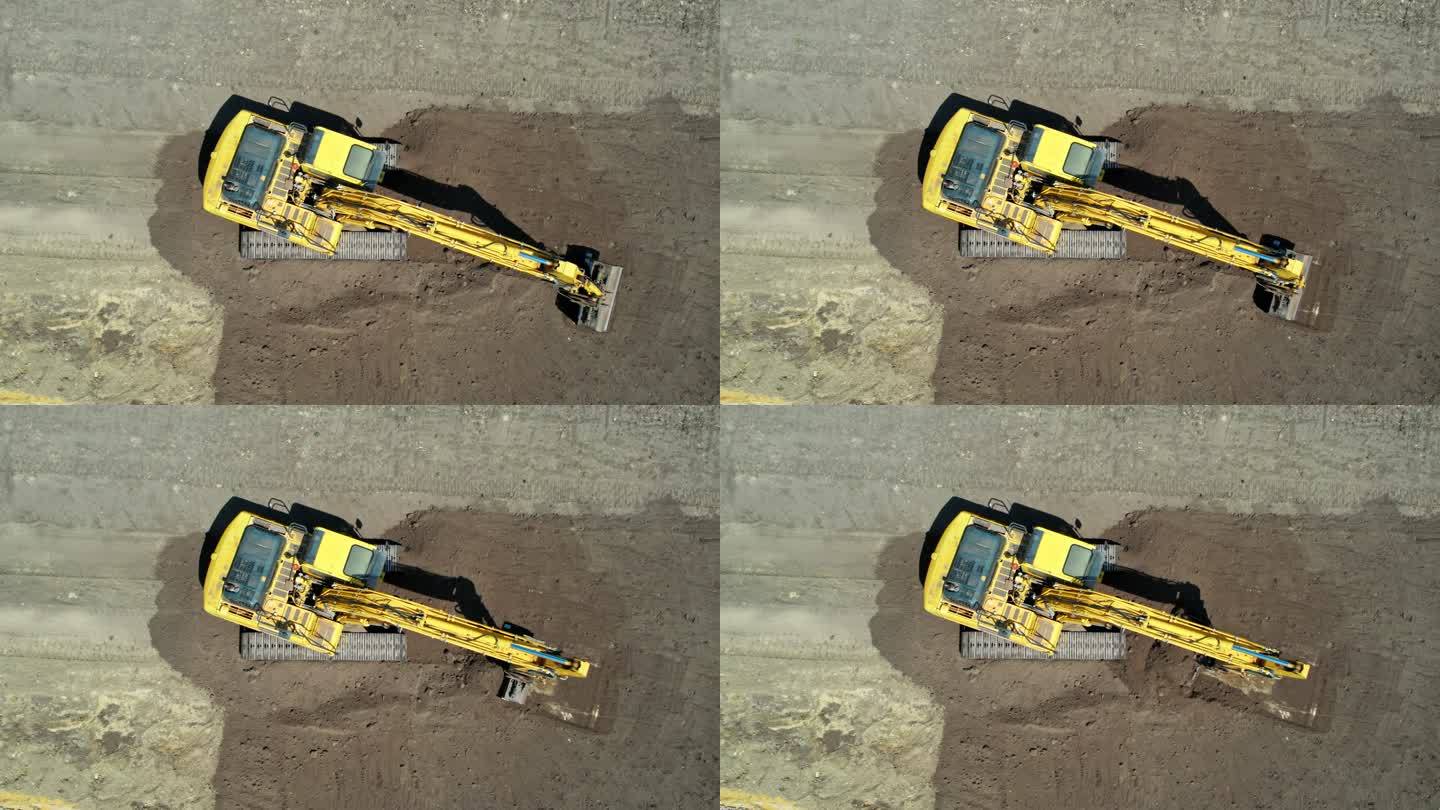 带有连续履带的黄色挖掘机。鸟瞰图。低空接近摄像机。整地挖掘机。施工现场准备。加注铲斗和驾驶室旋转。