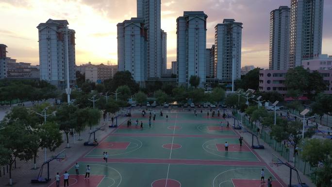 傍晚城市露天篮球场打篮球群众
