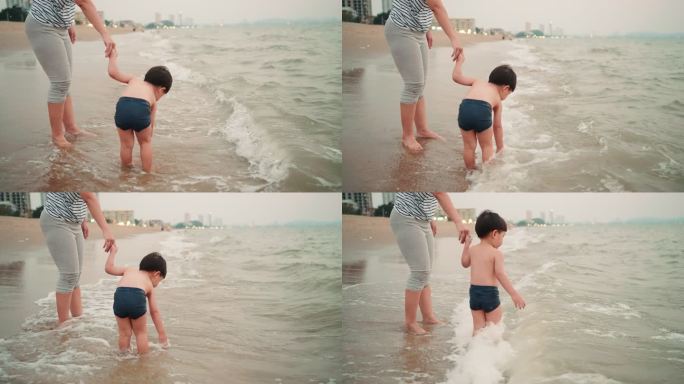 母亲手牵着手，小儿子在芭堤雅海滩上玩耍。