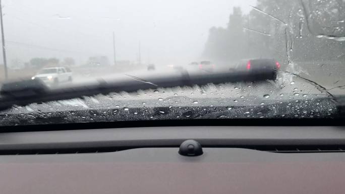 暴雨期间，公路司机通过雨滴汽车挡风玻璃观看视窗。