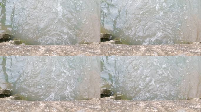 从混凝土平台上方到流经管道通道的水的特写镜头。