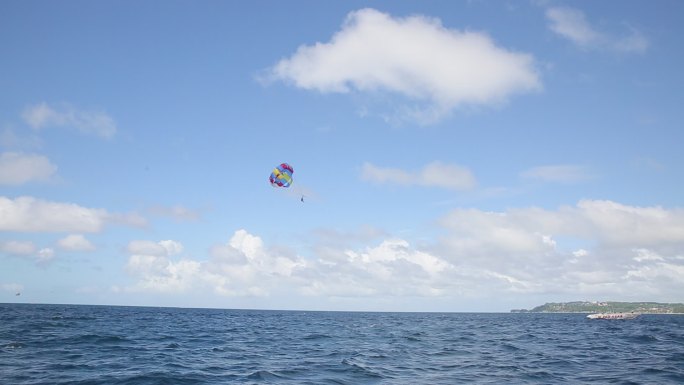 海上的彩色拖伞漂浮在蓝天中