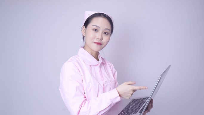 年轻女性医护形象手持笔记本电脑办公