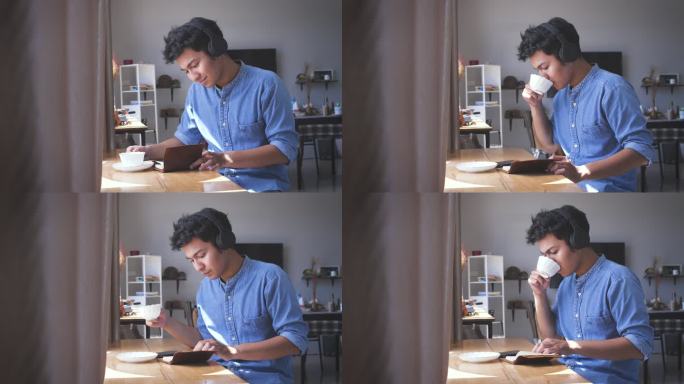 年轻的亚洲帅哥在家里一边看书一边用耳机听音乐，一边喝咖啡，人们放松的生活方式和科技理念
