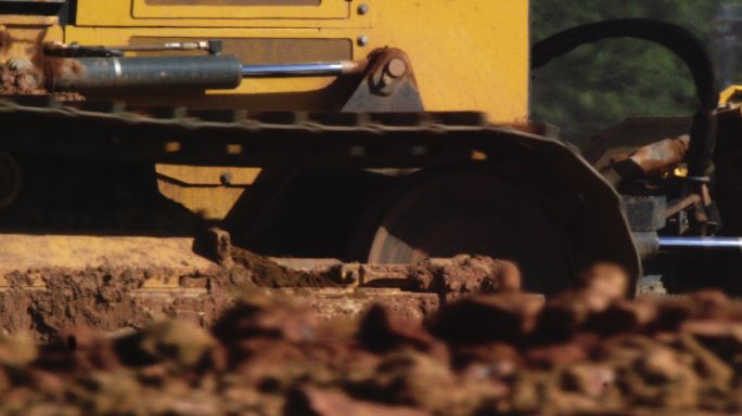 施工现场推土机在泥土上滚动的钢履带侧视图