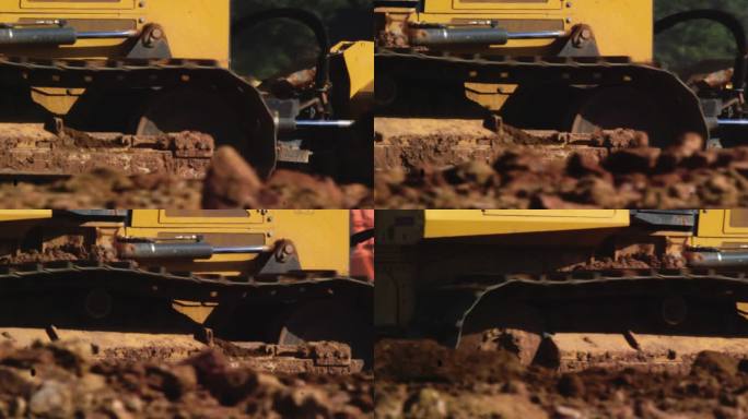 施工现场推土机在泥土上滚动的钢履带侧视图