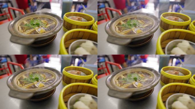 Bak kut teh是新鲜的，有热流和点心的中国菜，放在桌子上的竹篮里