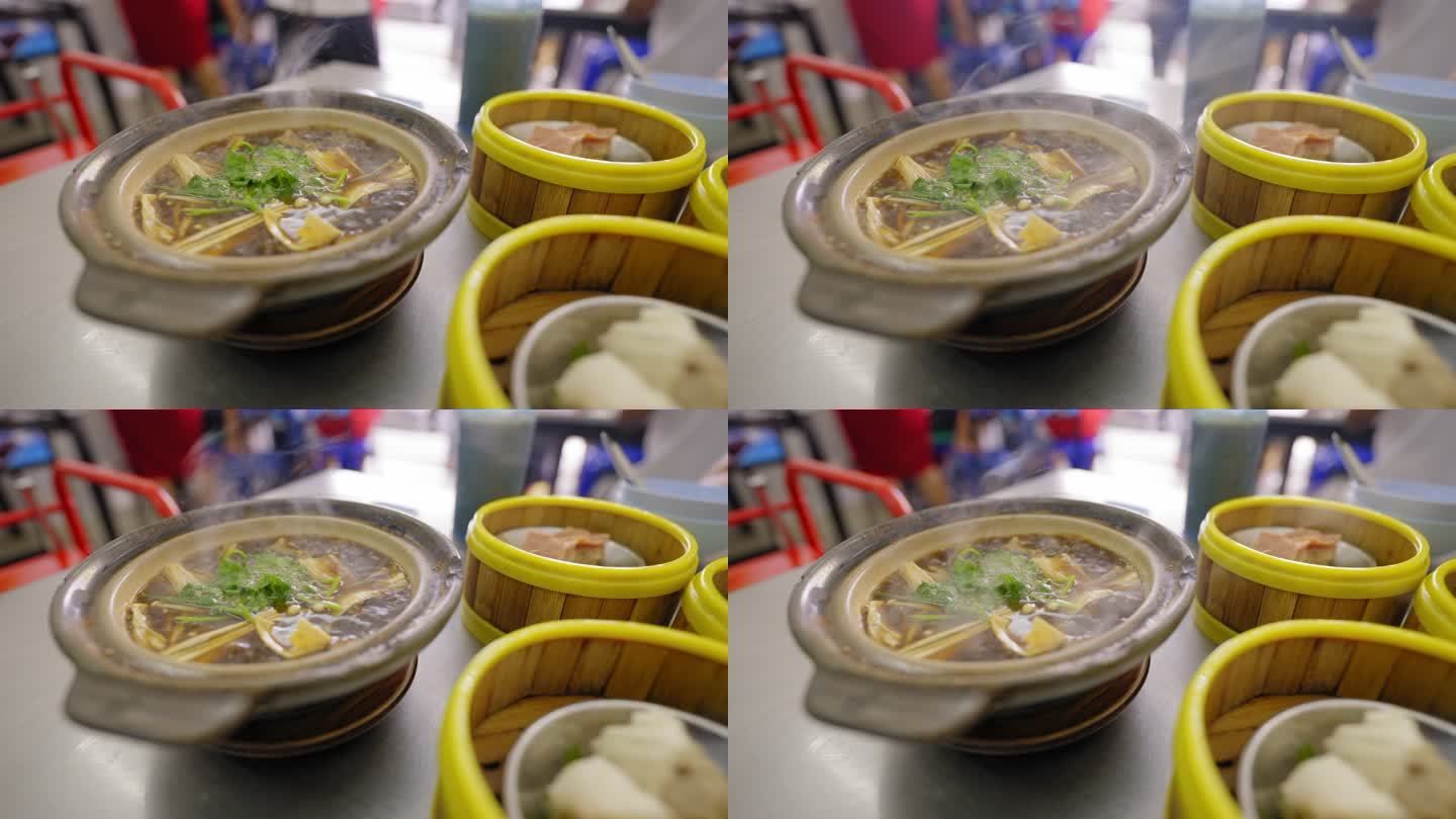 Bak kut teh是新鲜的，有热流和点心的中国菜，放在桌子上的竹篮里