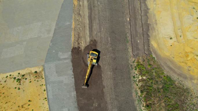 带有连续履带的黄色挖掘机。鸟瞰图。快速右转摄像机移动和缩小。整地挖掘机。施工现场准备。不同土层。