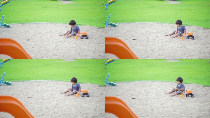 小男孩独自在操场上玩挖掘机玩具玩沙子