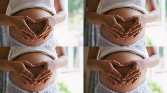 一名孕妇腹部形成心脏形状的4k视频片段