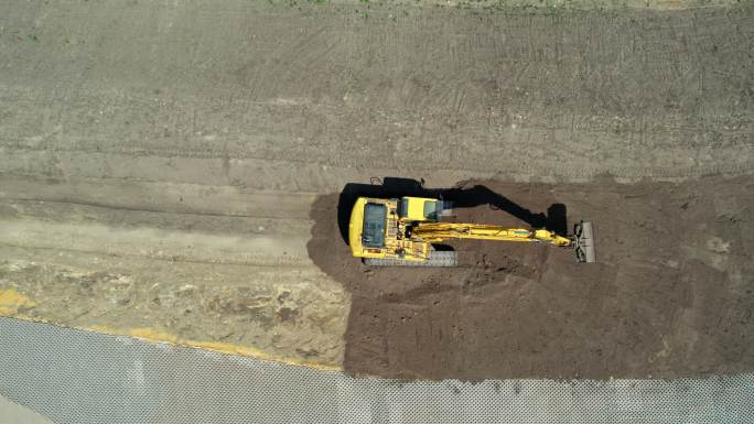 带有连续履带的黄色挖掘机。鸟瞰图。高海拔。整地挖掘机。施工现场准备。挖掘机臂向前移动。