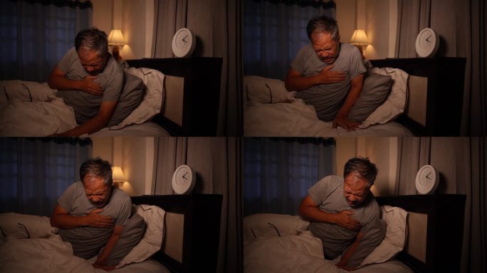 晚上躺在床上胸痛的亚洲男人。老人在床上心脏病发作。