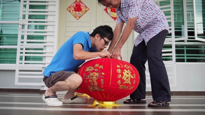 除夕之夜，亚裔中国父子在家前院准备红灯笼