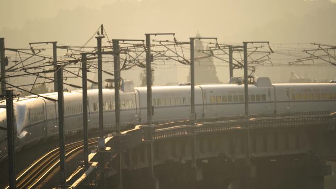 日出阳光下在城市中穿行的高铁火车