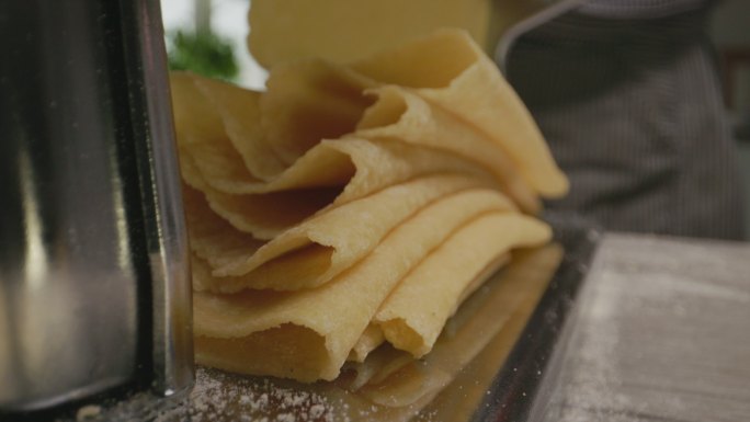 面食机上的新鲜折叠面食片特写