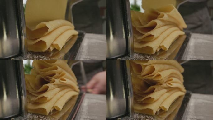 面食机上的新鲜折叠面食片特写