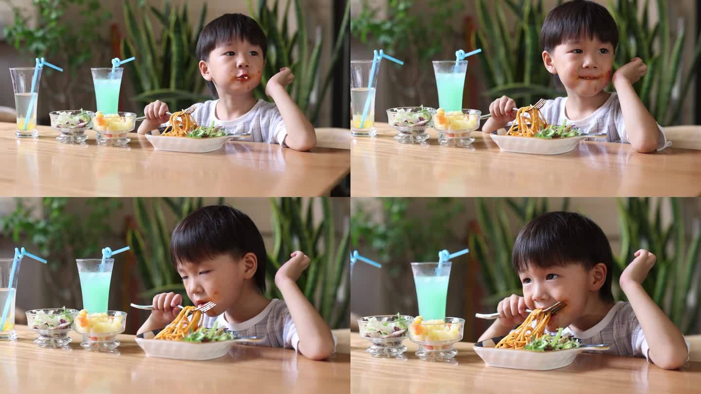 小男孩在餐厅吃饭儿童用餐小朋友吃面条三胎