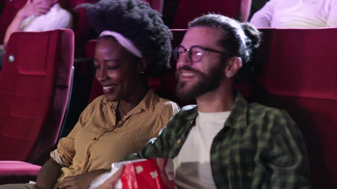 年轻的非洲女人和她的男朋友在电影院里看电影