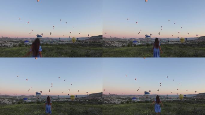 在卡帕多西亚，穿着裙子的快乐女人在风景秀丽的山谷中，手持热气球迎接日出
